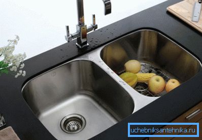 Die integrierte Spüle aus Edelstahl in einer Tischplatte aus einem Kunststein. Die integrierte Spüle aus Edelstahl in einer Tischplatte aus einem Kunststein.