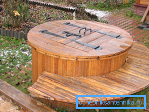 Auf dem Foto - ein Brunnen mit einem Klappdeckel. Auf dem Foto - ein Brunnen mit einem Klappdeckel.