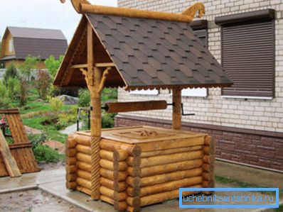 Auf dem Foto - ein Haus für einen Brunnen in Form eines Baumstamms Auf dem Foto - ein Haus für einen Brunnen in Form eines Baumstamms