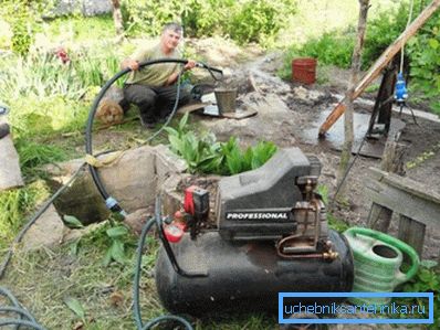 Auf einem Foto - Pumpen eines Brunnens nach dem Bohren Auf einem Foto - Pumpen eines Brunnens nach dem Bohren