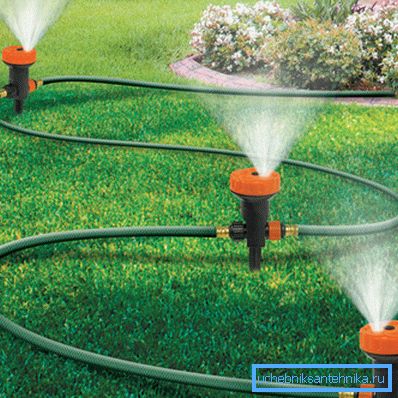 Das Foto zeigt eine Sprinklerdüse, die mit einem Gartenschlauch verbunden ist. Das Foto zeigt eine Sprinklerdüse, die mit einem Gartenschlauch verbunden ist.