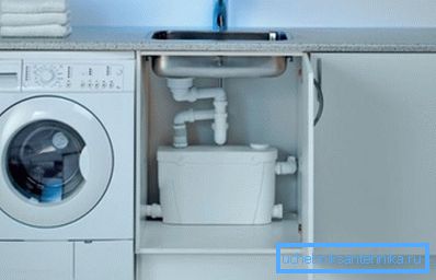 Auf dem Foto - Platzieren der Küchenmodifikation der Pumpe unter der Spüle Auf dem Foto - Platzieren der Küchenmodifikation der Pumpe unter der Spüle