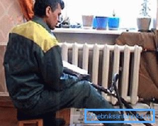 Auf dem Foto wäscht der Klempner die Heizkörper in der Wohnung Auf dem Foto wäscht der Klempner die Heizkörper in der Wohnung
