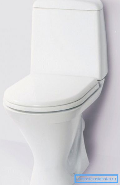 Auf dem Foto - eine Toilette mit einem Spülkasten an der Schüssel. Auf dem Foto - eine Toilette mit einem Spülkasten an der Schüssel.