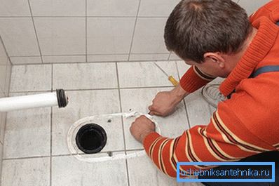 Bei der Installation einer Toilette mit vertikalem Auslass tritt die Düse in den Hals des im Boden montierten Rohrs ein Bei der Installation einer Toilette mit vertikalem Auslass tritt die Düse in den Hals des im Boden montierten Rohrs ein