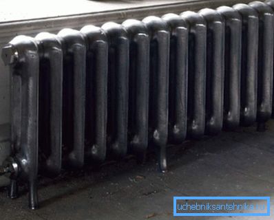 Unter dem Fenster installierter stationärer Bodengussheizkörper Unter dem Fenster installierter stationärer Bodengussheizkörper