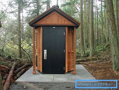 Isolierte Toilette auf einem Betonsockel mit Metalltür Isolierte Toilette auf einem Betonsockel mit Metalltür