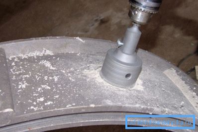 Schneiden Sie ein Loch für das Rohr in den Betonring. Schneiden Sie ein Loch für das Rohr in den Betonring.